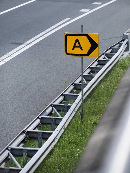 Trafik yönünü gösteren oklu A harfini gösteren sarı yol işaretinin yakın çekimi