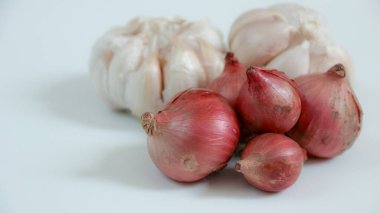 Hafif bir yüzeyde bir grup taze kırmızı soğan ve sarımsak soğanı. Mutfak projeleri ya da sağlıklı beslenme içerikleri için mükemmel..