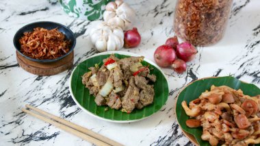 İki tabak et yemeği mermer bir yüzey üzerinde baharat ve taze soğanla servis edilir ve mutfak projeleri için lezzetli bir yemek sunumu oluşturur..