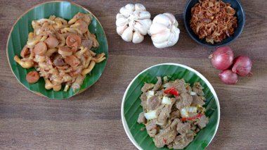 İştah açıcı yemekler ahşap bir masada sarımsak ve arpacık soğanı ile servis edilir. Mutfak sunumları ve yemek tarifi ilhamı için mükemmeldir..