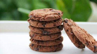 Beyaz bir yüzeye yığılmış taze çikolatalı kurabiyeler yemek blogları ve pişirme içeriği için mükemmel bir aperatif sunar..