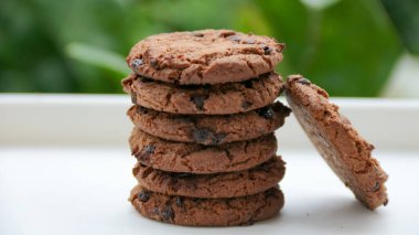 Beyaz bir yüzeye yığılmış taze çikolatalı kurabiyeler pişirme ve yemekle ilgili içerik için mükemmel bir tedavi görüntüsü yaratır..