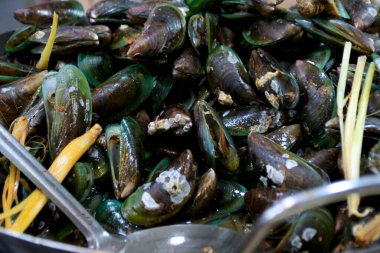 Taze yeşil midyeler limon otu ve metal kaşıkla hazırlanıyor. Bu da yemek hazırlığı ve deniz mahsulleri mutfağını öneriyor. Yemek blogları ve deniz ürünleri tarifleri için harika..