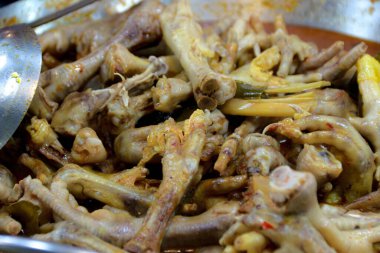 Geleneksel bir yemek ya da maceracı bir yemek blogu için metal bir kâsede sıcak servis edilen tavuk ayağı yığını..