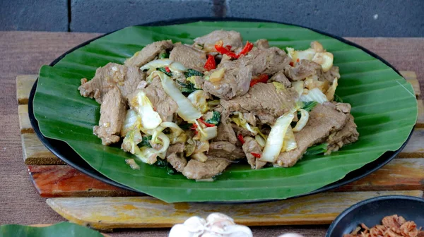 Yemek blogları ve restoran promosyonları için mükemmel eşsiz bir aşçılık deneyimi için canlı yeşil muz yaprağı tabağında lahana ve biberli tuzlu biftek servis edilir..