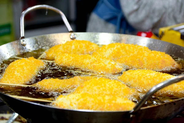 Sıcak köpüren yağla dolu bir tavada ahşap çubuklarda kızartılmış yiyecek parçaları yemek sokak yemekleri için mükemmel bir aperatif olur..