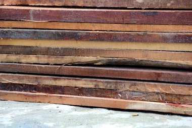 Yapı projeleri veya tasarım elementleri için ideal ahşap tahıl ve doku gösteren istiflenmiş kaba kereste yığınları.