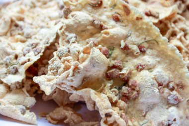 Yakın plan, kızarmış fıstık ve diğer baharatlarla birlikte ayarlanmış çıtır fıstıklı börekleri gösteriyor. Etnik yiyecekleri göstermek için mükemmel bir zaman yaratıyor..