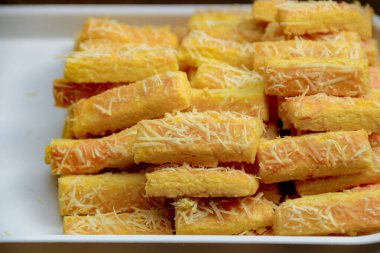 Beyaz bir tabağa istiflenmiş fırında peynirli hamur tatlısı yemek blogları ve yemek tarifleri paylaşımı için harika bir sunum hazırlıyor..