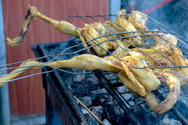Sıcak kömür üzerine tavuk ızgarası dışarıda yemek hazırlamak için duman yayar. Yemek ve yemek içeriği için mükemmeldir..