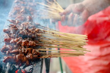 Et şişleri kızgın kömürlerin üzerinde ızgara yapıyor, dumanlar yükseliyor, el ele tutuşuyor, yemek blogu ya da sokak yemekleri promosyonu için mükemmel bir yemek sahnesi yaratıyor..