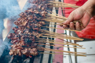 El ele tutuşmuş et şişleri kömürün üzerinde ızgara yapıyor, duman yayıyor. Yemek hazırlamak ya da yemek pişirmek için mükemmel..