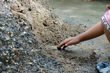 Bir çocuk dışarıda çamur ve suyla oynar, keşfederken ve çamurlanırken görüntüler bir çocuğun doğa aktivitelerini ve açık hava yaşam tarzını gösterir..