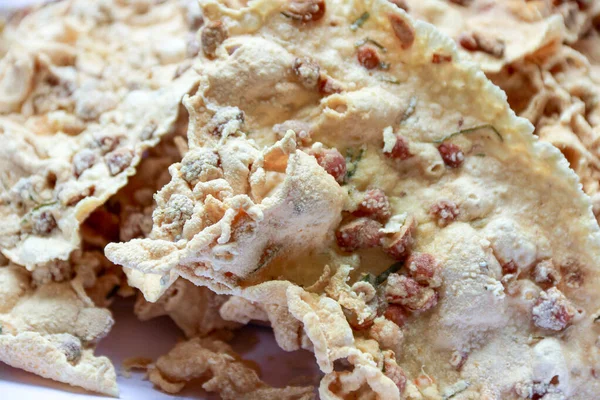 Yakın plan, kızarmış fıstık ve diğer baharatlarla birlikte ayarlanmış çıtır fıstıklı börekleri gösteriyor. Etnik yiyecekleri göstermek için mükemmel bir zaman yaratıyor..