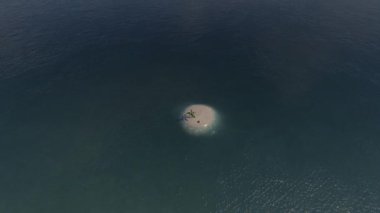 İş adamı bir adada bavuluyla bekliyor.