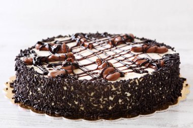 Mascarpone krema, çikolata parçacıklı ve ahşap rustik masa üzerinde eritilmiş çikolata tepesi ile lezzetli ev yapımı pasta