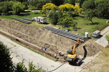 VARNA, BULGARIA - JUNE 30, 2017: Changing the pipes of the municipal district heating and hot water supply system clipart