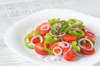 Cherry domates, kırmızı soğan, yeşil biber halkaları, maydanoz ve zeytinyağı ile sağlıklı, taze ve lezzetli sebze salatası