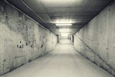Empty, tunnel like downhill ramp of an underground car parking. Black and white image clipart