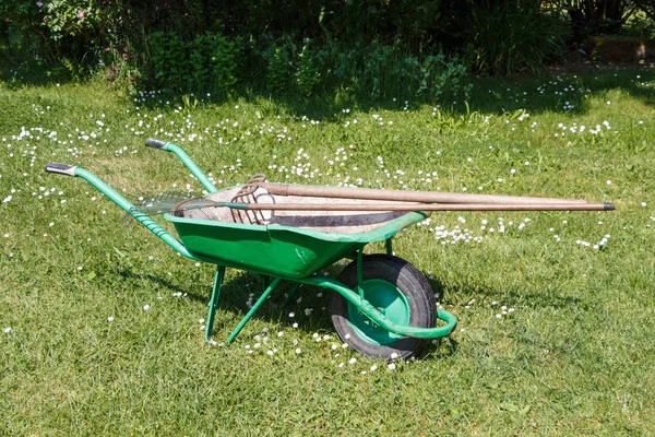 Bir bahçede çim komisyon ve pençe Kültüvatör ile yeşil el arabası