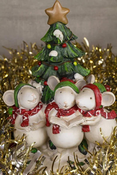 Mouses figurines singing for Christmas, fir tree and golden tinsel