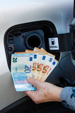 Euro banknot bir araba tank yakınındaki bir kadınla el