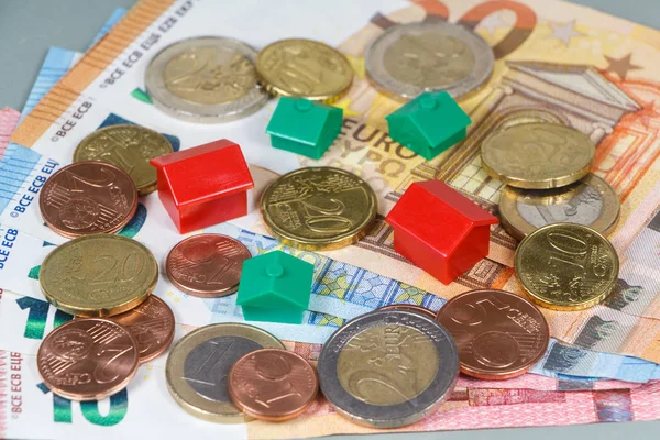 Euro banknotes, coins and house — Stock Photo, Image