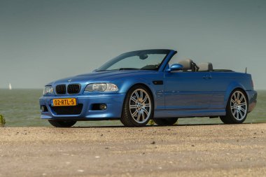 NETHERLANDS - MAY 20, 2018: convertible BMW M3 e46 standing outdoors near IJsselmeer on sunny day clipart