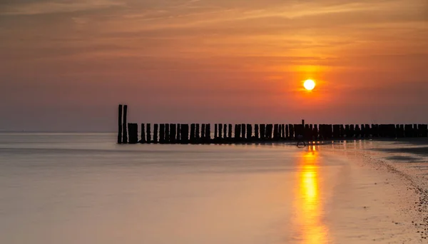 Dřevěné Sloupy Moři Krásný Západ Slunce Holandském Pobřeží — Stock fotografie