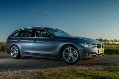 Hollanda - 8 Mayıs, 2017: Hollandalı polder önünde duran bir gün batımı touring Bmw 320i.