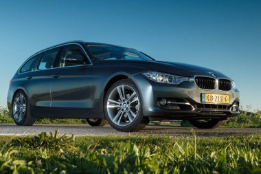 Hollanda - 8 Mayıs, 2017: Hollandalı polder önünde duran bir gün batımı touring Bmw 320i.