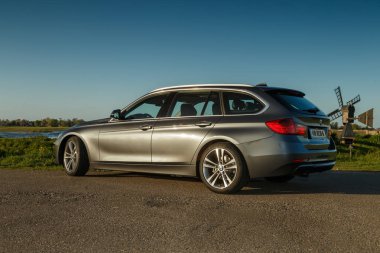 Hollanda - 8 Mayıs, 2017: Hollandalı polder önünde duran bir gün batımı touring Bmw 320i.