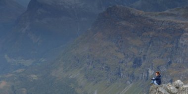 Arayan kadın binaya Geiranger Dalsnibba dağları oluşturmak.