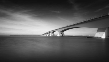 liman ve bulutlu gökyüzü üzerinde köprü siyah beyaz görüntü