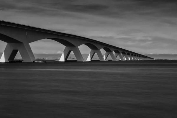 Zwart Wit Beeld Van Brug Rivier Bewolkte Hemel — Stockfoto