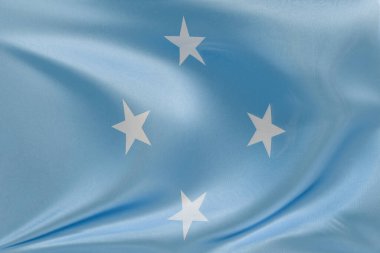 Mikronezya Birleşik Devletleri 'nin bayrağını sallıyor, kumaş dokusuyla, nazikçe dalgalanıyor ve katlanıyor, pürüzsüz, dinamik hareket ve zarif tekstil detaylarıyla özgürlük ve kimliğin özünü yakalıyor..