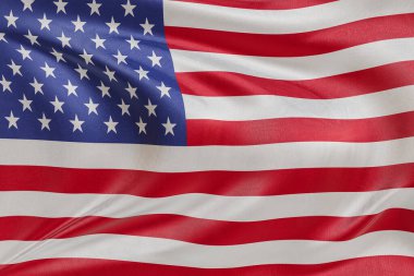 ABD bayrağını dokulu kumaşla sallamak, nazikçe dalgalanmak ve katlanmak, pürüzsüz, dinamik hareket ve zarif tekstil detaylarıyla özgürlük ve kimliğin özünü yakalamak..