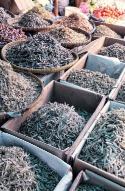 Geleneksel Asya pazarında sepet ve kutularda sergilenen çeşitli kurutulmuş ançüezler ve deniz ürünleri yerel mutfak malzemelerini gösteriyor. Riau, Endonezya. 21 Mayıs 2021