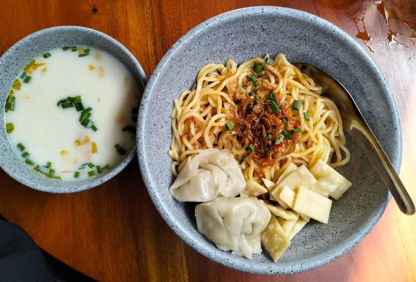 Geleneksel Endonezya tavuklu erişte, mantı, kızarmış wonton ve seramik kaselerde ayrı çorba çorbası ile servis edilir..