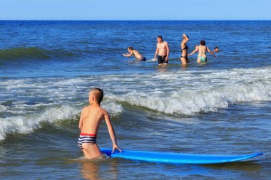 Zelenogradsk, Kaliningrad bölgesi, Rusya Federasyonu - 29 Temmuz 2017: Bilinmeyen çocuk dinlenme ve yaz saati, Baltık Denizi'nin mavi dalgalar üzerinde sörf öğrenme surfboard ile.