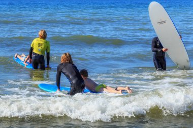 Zelenogradsk, Kaliningrad bölgesi, Rusya Federasyonu - 29 Temmuz 2017: dinlenme ve yaz saati, Baltık Denizi'nin mavi dalgalar üzerinde profesyonel eğitmenler ile sörf öğrenme bilinmeyen çocuk.
