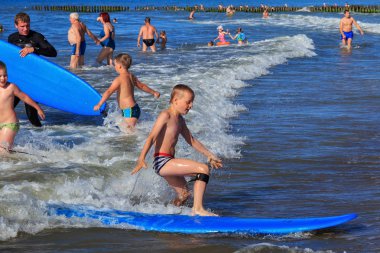Zelenogradsk, Kaliningrad bölgesi, Rusya Federasyonu - 29 Temmuz 2017: dinlenme ve yaz saati, Baltık Denizi'nin mavi dalgalar üzerinde profesyonel eğitmenler ile sörf öğrenme çocuk.