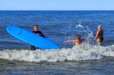 Zelenogradsk, Kaliningrad bölgesi, Rusya Federasyonu - 29 Temmuz 2017: Bilinmeyen sörfçü ile Baltık Denizi'nin mavi sularına yaz zaman sörf tahtası ayakta.