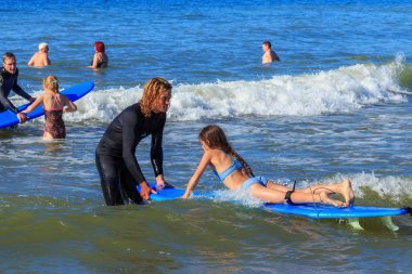 Zelenogradsk, Kaliningrad bölgesi, Rusya Federasyonu - 29 Temmuz 2017: dinlenme ve yaz saati, Baltık Denizi'nin mavi dalgalar üzerinde profesyonel eğitmenler ile sörf öğrenme bilinmeyen çocuk.