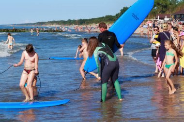 Zelenogradsk, Kaliningrad bölgesi, Rusya Federasyonu - 29 Temmuz 2017: Bilinmeyen sörfçü ile ünlü tatil Zelenogradsk yaz saati, Baltık Denizi kıyısında kumlu bir plaj üzerinde sörf tahtası duran.