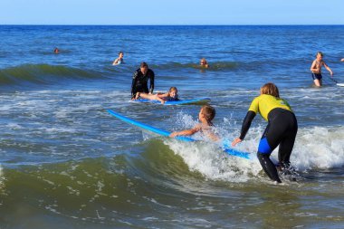 Zelenogradsk, Kaliningrad bölgesi, Rusya Federasyonu - 29 Temmuz 2017: dinlenme ve yaz saati, Baltık Denizi'nin mavi dalgalar üzerinde profesyonel eğitmenler ile sörf öğrenme bilinmeyen çocuk.