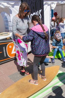 Zelenogradsk, Kaliningrad bölgesi, Rusya Federasyonu - 29 Temmuz 2017: ünlü deniz Resort (eski Cranz da bilinir) Zelenogradsk simüle bir sörf tahtası üzerinde dengelemek yaz zaman öğrenme bilinmeyen genç kız.