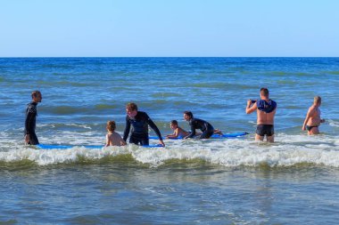 Zelenogradsk, Kaliningrad bölgesi, Rusya Federasyonu - 29 Temmuz 2017: dinlenme ve yaz saati, Baltık Denizi'nin mavi dalgalar üzerinde profesyonel eğitmenler ile sörf öğrenme bilinmeyen çocuk.