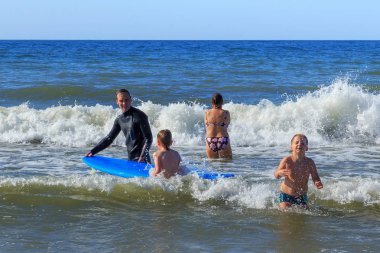 Zelenogradsk, Kaliningrad bölgesi, Rusya Federasyonu - 29 Temmuz 2017: dinlenme ve yaz saati, Baltık Denizi'nin mavi dalgalar üzerinde profesyonel eğitmenler ile sörf öğrenme bilinmeyen çocuk.