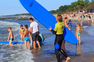 Zelenogradsk, Kaliningrad bölgesi, Rusya Federasyonu - 29 Temmuz 2017: Bilinmeyen sörfçü ile ünlü tatil Zelenogradsk yaz saati, Baltık Denizi kıyısında kumlu bir plaj üzerinde sörf tahtası duran.